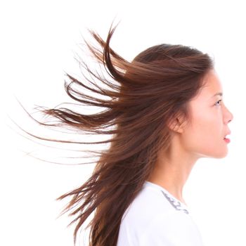 Profile closeup of Isolated girl running with hair flying in the wind. Studio shot isolated on white background. Mixed race chinese / caucasian model.