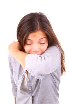 Woman having the flu and sneezing on her sleeve in the elbow crook of her arm. Isolated on white background.