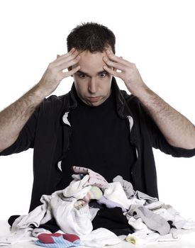 A young man looks frustrated at having to sort laundry or socks, isolated against a white background.