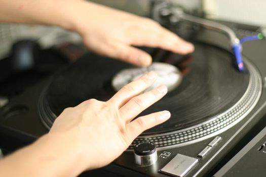 scratch battle of dj playing on his vinyls hand on