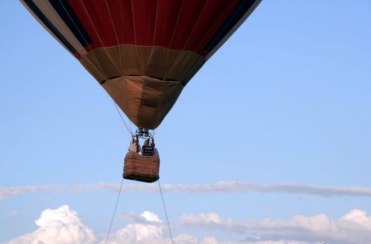 hot-air balloon with people rises in the sky 