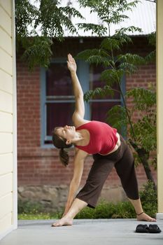 Pretty Young Woman doing Yoga on a Porch 