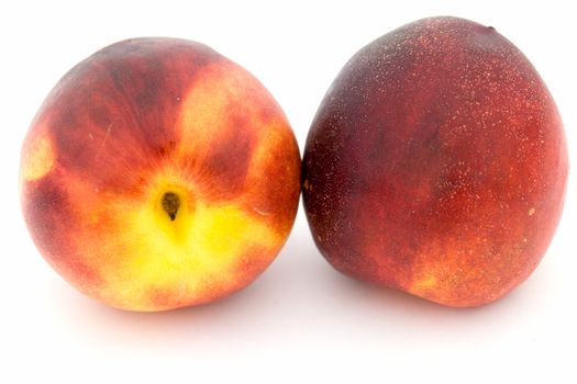 Two ripe nectarines on a white background