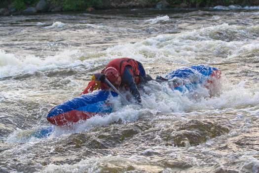 sportsmen on the blue catamaran in the rapid 
