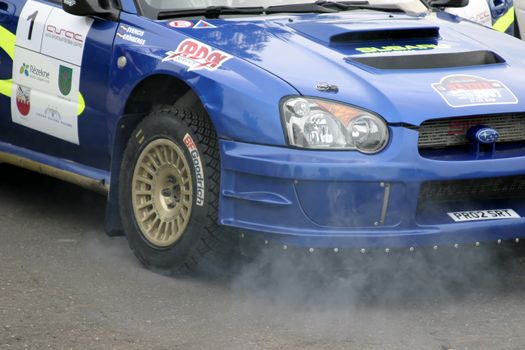 Fuming engine of rally car. Editorial image.