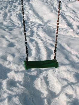 An empty swing on winter park.