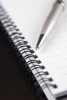 Closeup of a notebook and a ballpoint pen