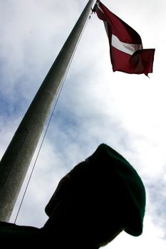 Man with a latvian red and white flag