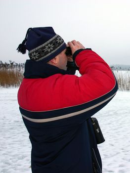 The man looking into binoculars
