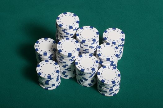 Poker chips stacked up on a green felt poker table
