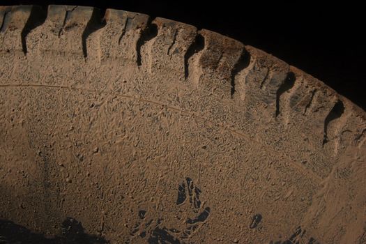 Car tire covered in dirt and mud after driving offroads