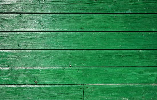 Green wooden wall with old and weathered paint