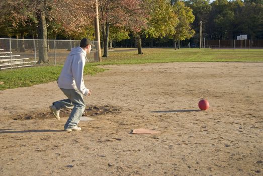 A friendly game of kick ball at the park - just like at recess back in the day.