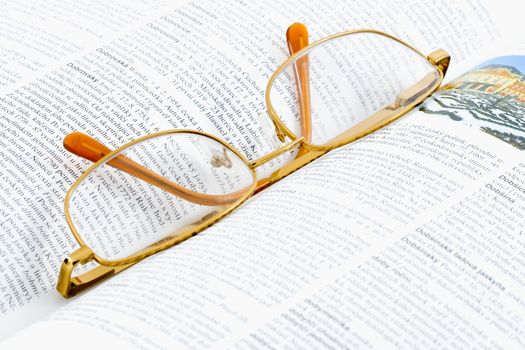 glasses lying on an open book - close up