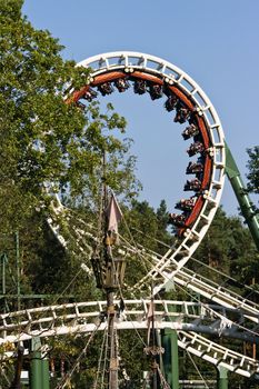 Rollercoaster in amusement park with a blue sky background