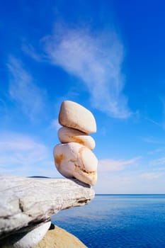 A three white pebbles on the brink of marine rock