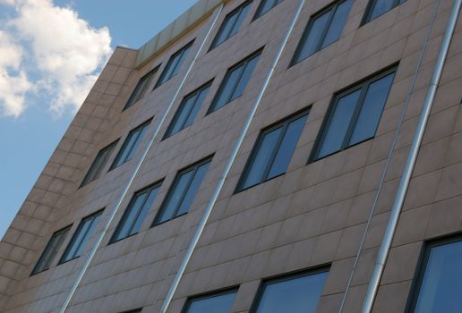 view of new modern office building and sky with clouds