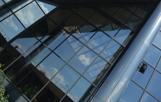 front of new modern office building with reflections of clouds