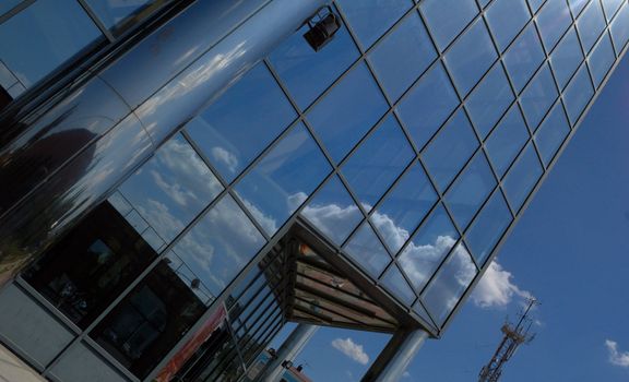 front of new modern office building with reflections of clouds