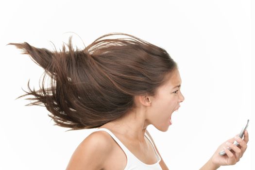 Screaming angry woman on the mobile phone. Dynamic and energetic image of young mixed race chinese / caucasian woman isolated on seamless white background. 