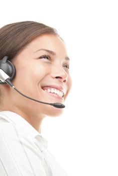 Headset woman in semi profile - smiling very kindly. Closeup of beautiful young mixed race chinese / caucasian secretary / assistant speaking with headphones while working in call center. Isolated on seamless white background.