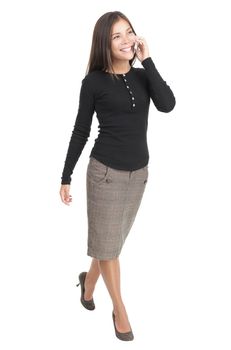 Businesswoman isolated walking in full length with mobile phone. Casual beautiful young mixed race chinese / caucasian business woman isolated on seamless white background.