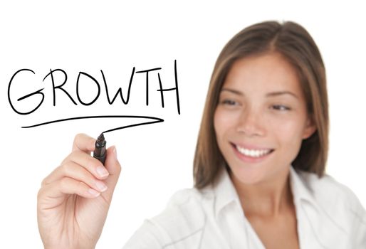 Growth and success in business concept. Young beautiful businesswoman with pen writing growth on whiteboard. Focus on the black marker. Mixed race Chinese / Caucasian model isolated on white background.  
