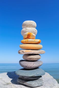 Balancing a few of pebbles on against the blue sky