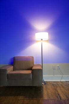 Modern chair and floor lamp with blue cast from projection.