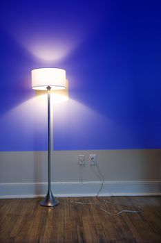 Blue projection light on wall with bright floor lamp.