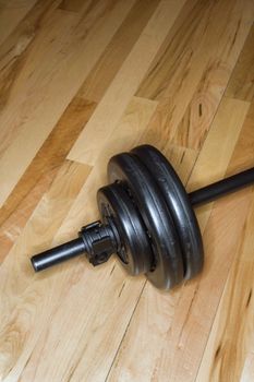 Barbell with weights on gym floor.