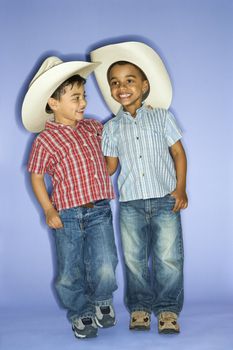 Hispanic and African American male child in cowboy hats.