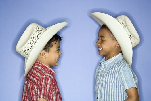 Hispanic and African American male child in cowboy hats.