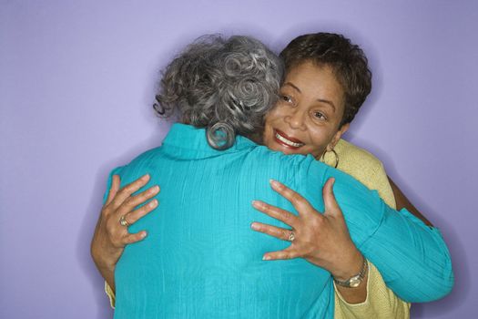 Mature adult African American females embracing.