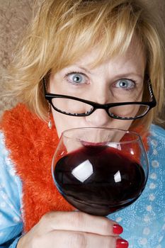 Crazy woman with wild eyes drinking wine 