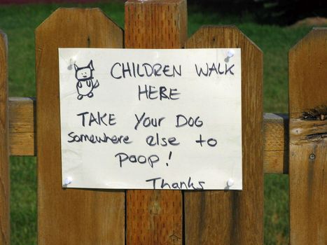 A sign posted on a fence by a convenience store.
