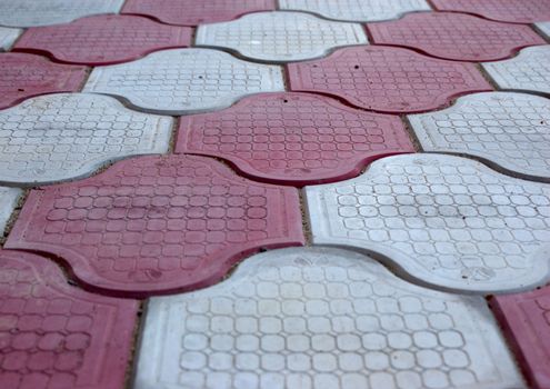 close-up of new old-style pavement of figured stoneblocks (bricks) of red and light color