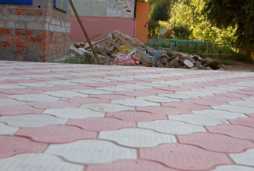 close-up of new old-style pavement of figured stoneblocks and heap of construction rubble