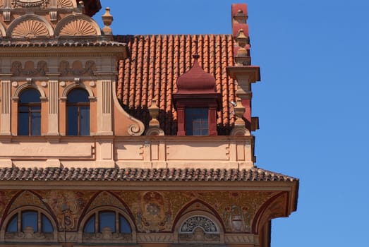 Photo of a part of an old building with stucco mouldings on a pediment.