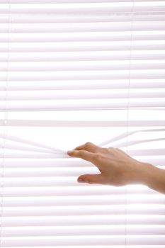 hands apart on the window blinds
