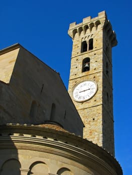 A medieval, renaissance bell and clock tower at the basilica in San Gimignano, Italy in Tuscany.

