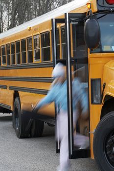 an out of focus student getting off a school bus