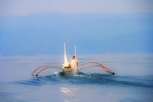 fishermans boat sailing at the mystic blue sea
