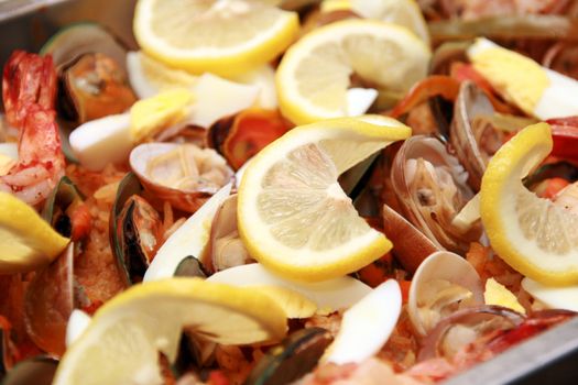 close-up of seafood paella with lots of lemon toppings
