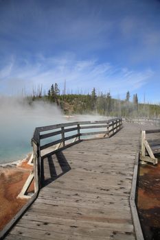 Wooden bridge through steaming geothermal hot springs on the shore of Yellowstone Lake