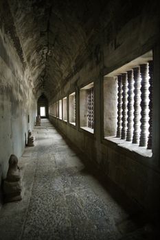 A corridor of the Angkor temples in Siem Reap, Cambodia.  The heads of the Buddha statues have been stolen or vandalized over the years of the temples neglect.
