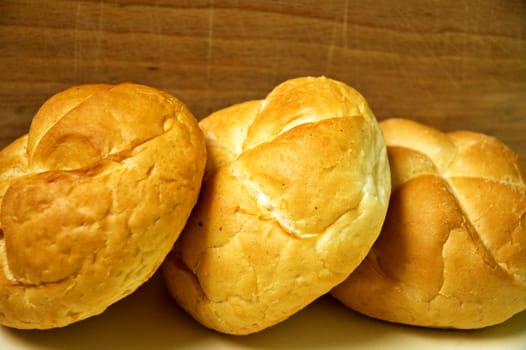 Three bread roll on kitchen table.