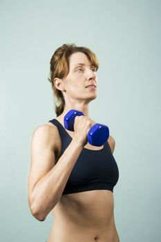 Pretty athletic woman working out with dumbbells