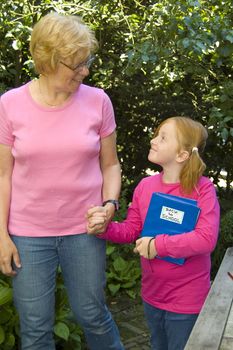 elderly woman is bringing little girl to school