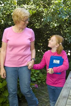 elderly woman is bringing little girl to school